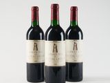 three bottles of red wine sitting next to each other on a white surface