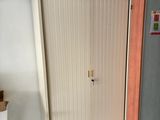 a cupboard in the corner of a room with boxes on top of it