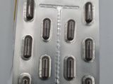 a close up of a package of pills on a white surface