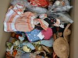 a cardboard box filled with dolls and other items