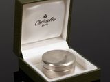 a silver ring in a green box on a black surface