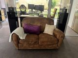 a brown couch with a purple pillow on it in a living room