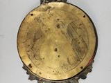 a gold plate on the wall with a clock on it