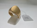 une image d'une bague en or sur une surface blanche avec une étiquette de prix