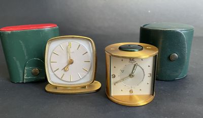 three different clocks sitting next to each other on top of a table