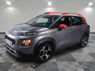 Une Citroën grise est garée dans une pièce au sol carrelé