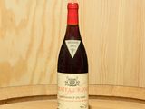 une bouteille de vin posée sur un tonneau en bois