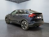 the rear end of a blue car in a white room