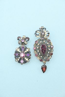 two pairs of earrings on a blue surface