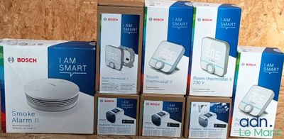 plusieurs cartons contenant des appareils électroniques posés sur une table en bois
