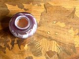 un vase violet posé sur une table en bois