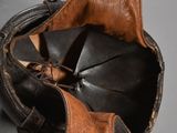 an old leather baseball glove with a leather hat on it