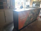 une photo d'un comptoir dans un magasin sur lequel est accrochée une affiche