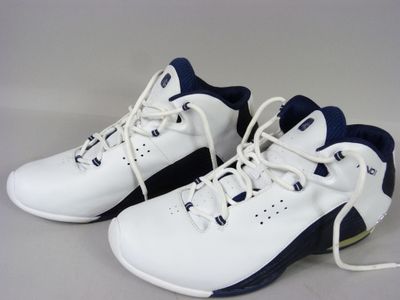 pair of white and blue sneakers with laces on a gray surface