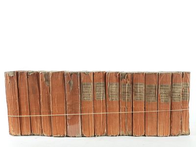 several old books stacked on top of each other on a white surface