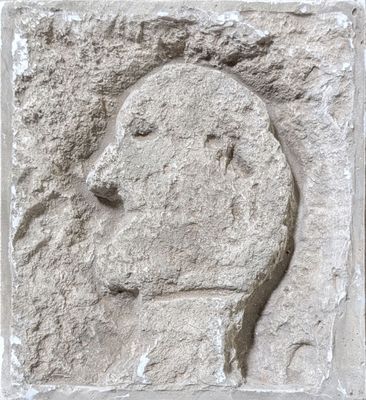 relief représentant le visage d'un homme sur un bloc de pierre