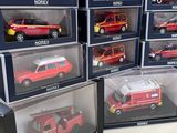 a lot of red toy cars in boxes on the table