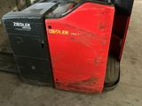 a red and black forklift sitting in a warehouse