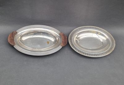 a pair of silverplated dishes on wooden bases