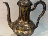 a silver tea pot sitting on a white table