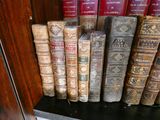 de nombreux livres anciens posés sur une étagère dans une pièce