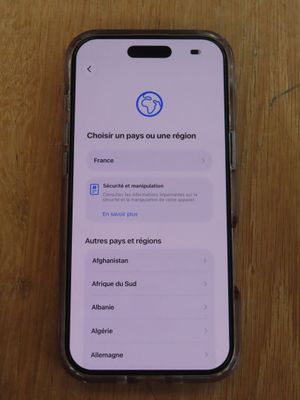 un gros plan d'un téléphone portable posé sur une table en bois