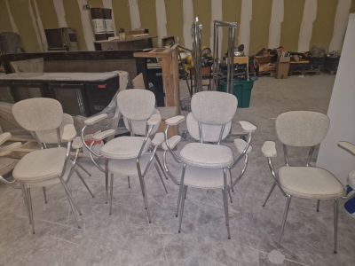 Plusieurs chaises sont disposées en cercle au milieu d'une pièce.