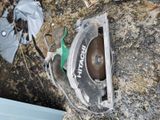 a circular saw sitting on the ground next to a trash can
