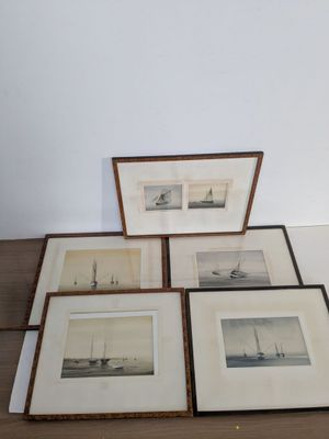 trois photos encadrées représentant des bateaux sont posées sur une table dans une pièce