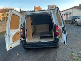 à l'arrière d'une camionnette dont la porte avant et la porte arrière sont ouvertes