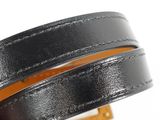 a close up of a hand holding a black leather bracelet
