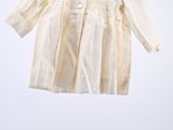 an image of a baby ' s white shirt hanging on a clothes rack