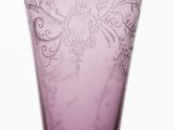 purple glass vase with a floral design on the outside of it