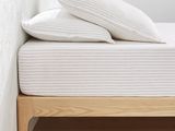 a bed with two pillows on top of it in a room