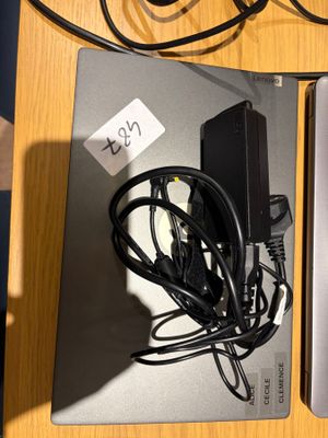 deux ordinateurs portables posés sur une table, avec des câbles et un chargeur