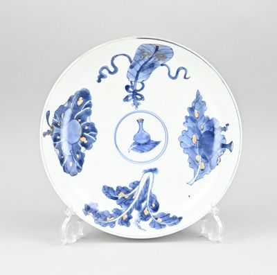 a blue and white plate with flowers and leaves on it