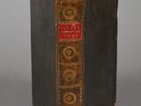 an old book sitting on top of a table on a gray surface