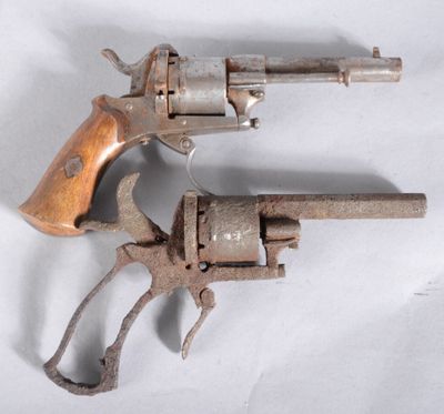 an old gun with a wooden handle on a white surface