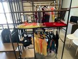 a room with a rack of clothes and a chair in it