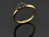 gros plan d'une bague en or avec une pierre en saphir