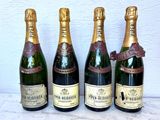 quatre bouteilles de champagne sont alignées sur une table