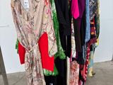 clothes hanging on a rack in front of a white wall