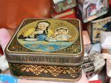 a small tin box with a picture of a woman and a child on it