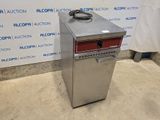 a silver refrigerator sitting on top of a floor next to a wall