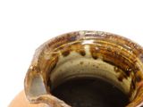a brown vase sitting on a table with a white background