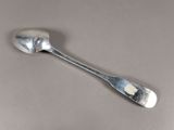 une cuillère en argent avec un manche de cuillère sur une table