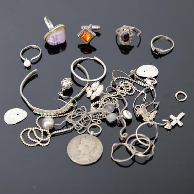plusieurs bagues et bracelets posés sur une table, à côté d'une pièce de monnaie