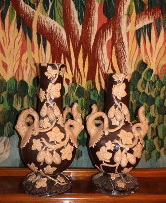 deux vases posés sur une étagère devant un tableau