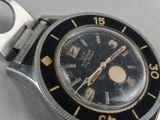 an image of a wrist watch with a black face and gold numbers
