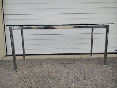 a metal table with a glass top in front of a garage door
